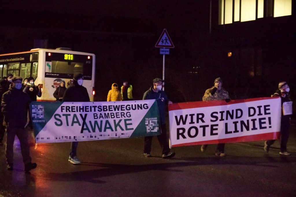 Roger Kuchenreuther (zweiter von rechts) führt den Demonstrationszug von „Stay Awake“ Bamberg mit einem Banner mit der Aufschrift „Wir sind die Rote Linie!“ an.